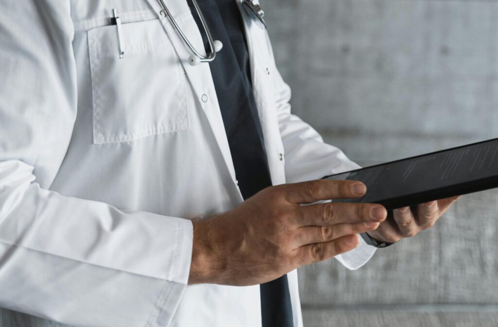 Portrait of a confident male doctor using a tablet indoors.